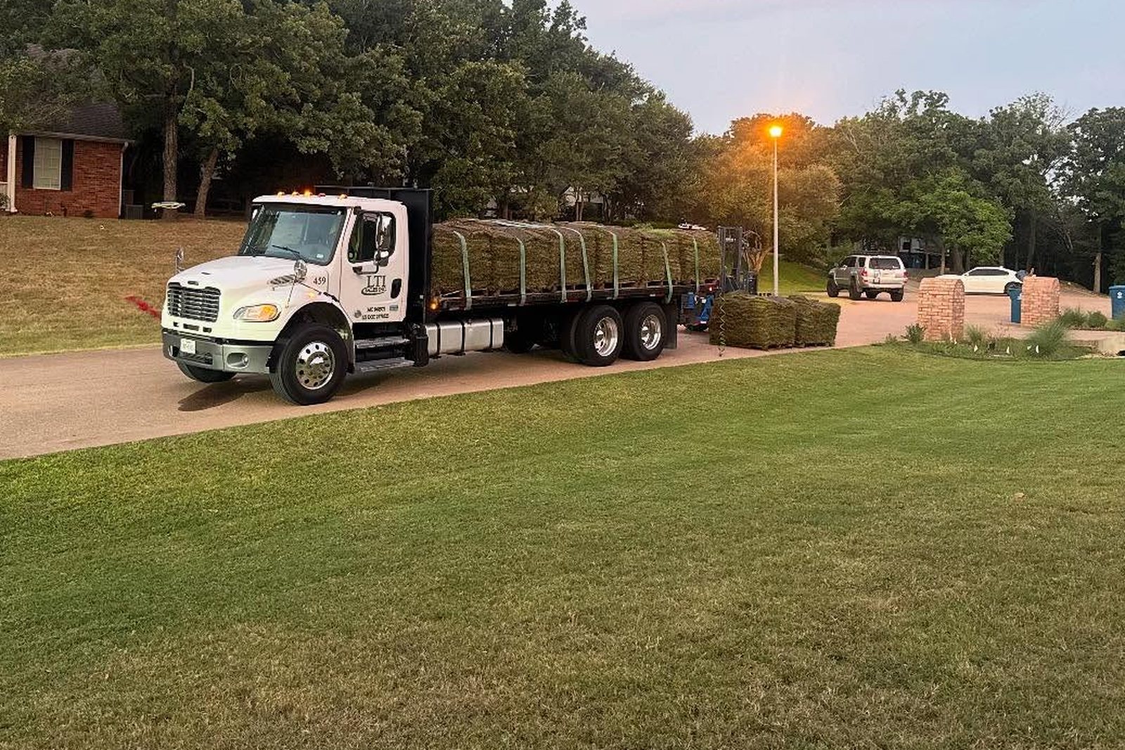 New sod being unrolled onto prepared soil in a Mansfield yard